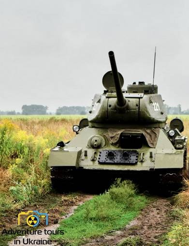 T-34 tank standing in the field with the canon lifted.jpg