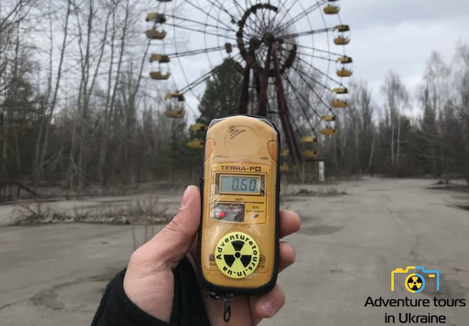 a hand holding the radioactivity counter near the ferris wheel in prypiat
